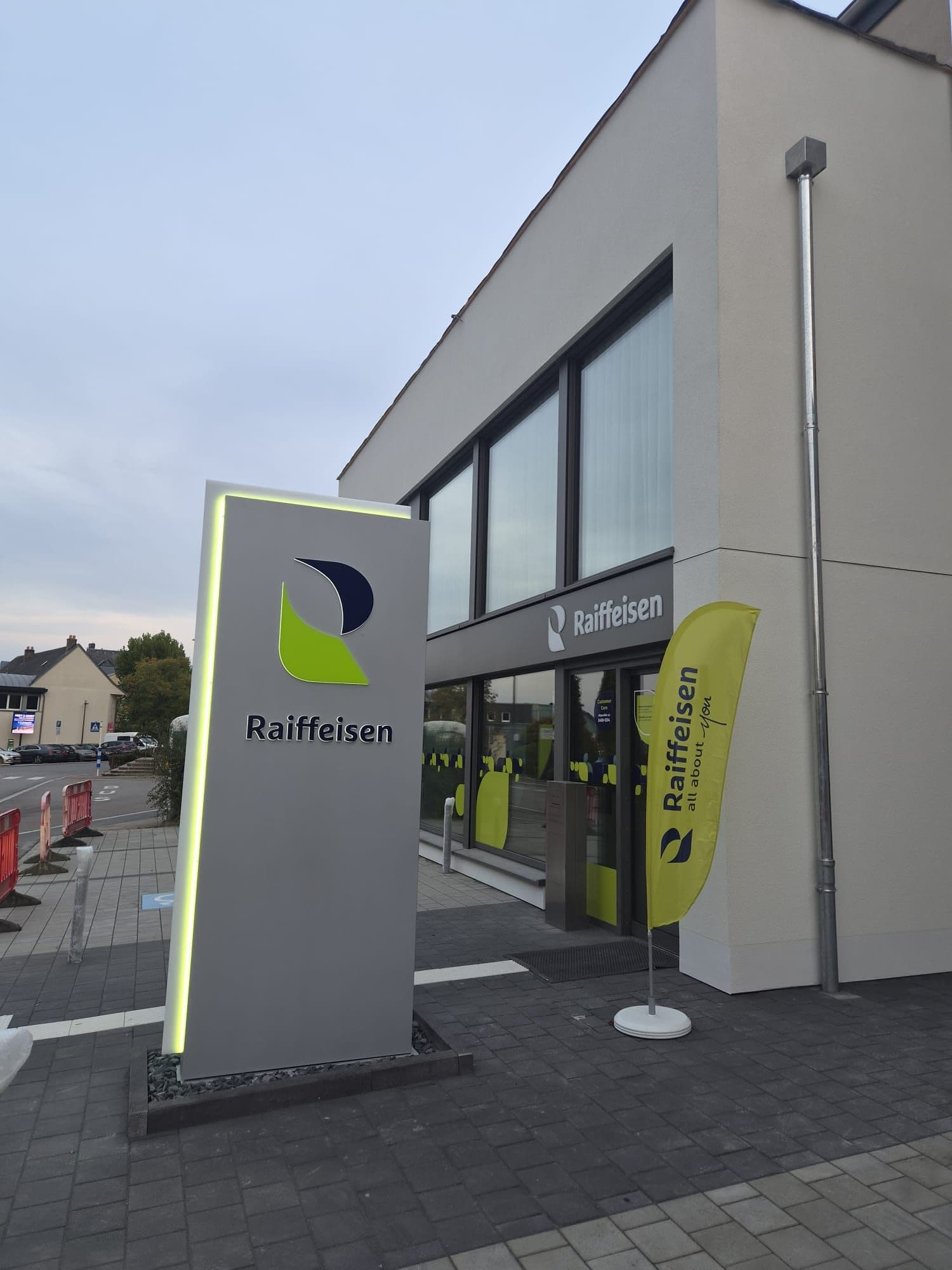 Beleuchtetes Raiffeisen-Totem vor der Filiale